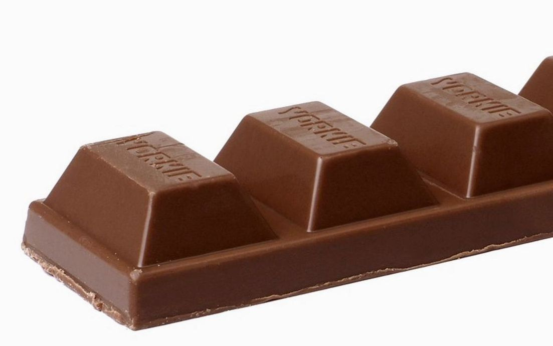 Una caja de caramelos de canela artesanales sobre una bandeja de madera